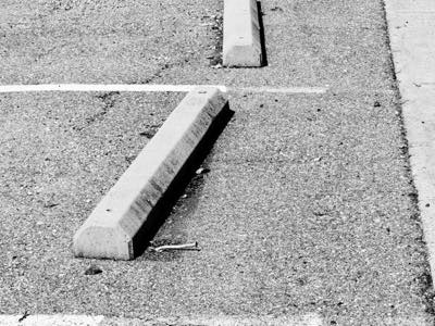 Concrete car stops lining an asphalt parking lot