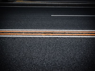 Road lane markings and raised pavement markers on asphalt
