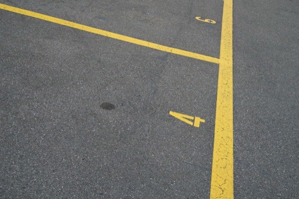 Florida Sealcoating crew installing parking lot signage