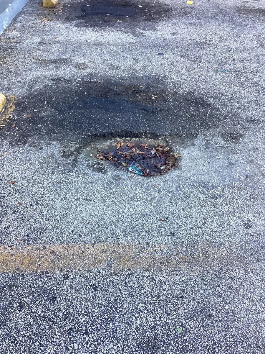 Oil-stained asphalt breaking down and losing structural integrity from petroleum penetration
