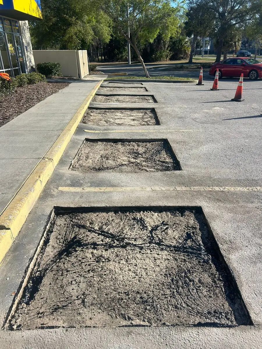 Single asphalt patch repair on an oil-damaged parking stall